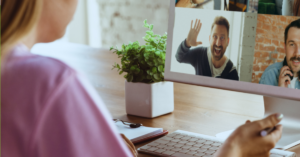 Woman logging onto a video call and her co-workers are very excited to see her