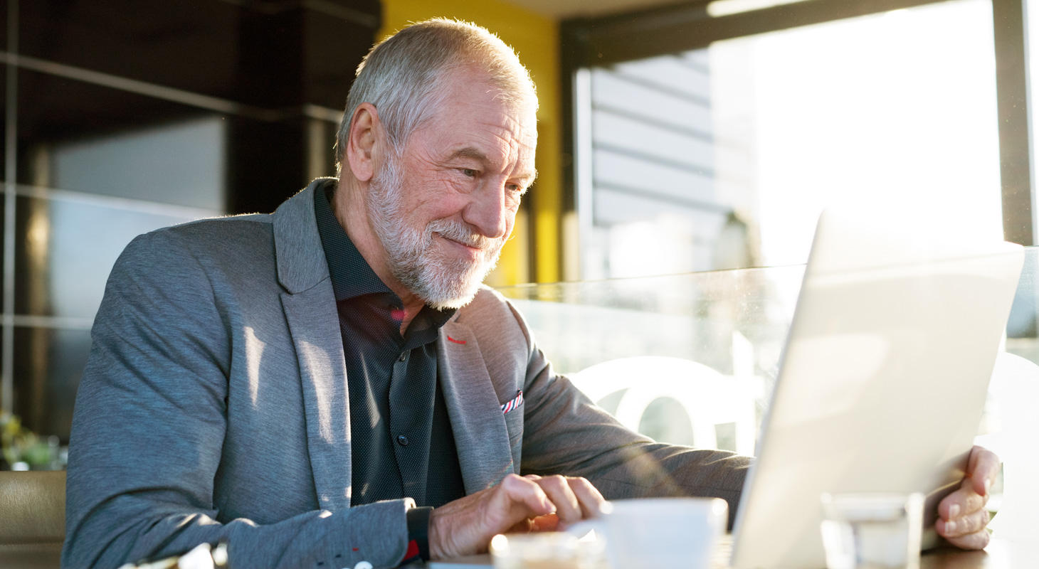 Senior businessman working on laptop in cafe People Using Mobile Devices