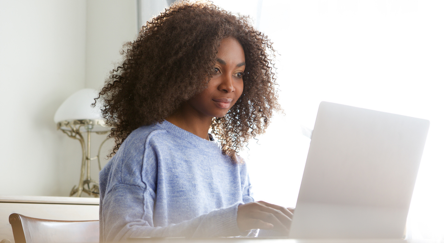 attractive young african woman sitting at home and working on la People Using Mobile Devices